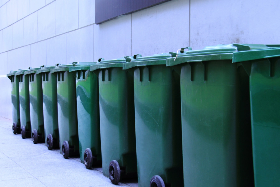 green small dumpsters outside of a house